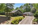 Desirable home featuring an RV garage, long driveway, and beautifully landscaped front yard at 109 Rustler Rd, Louisburg, NC 27549
