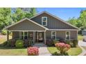 Attractive home with a welcoming front porch and beautifully landscaped garden with colorful shrubs at 109 Rustler Rd, Louisburg, NC 27549