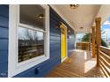 Inviting front porch showcasing a vibrant yellow door, complemented by stylish light fixtures and a cozy welcome mat at 1100 Chester St, Durham, NC 27701