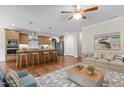 Spacious living room with hardwood floors, ceiling fan, and kitchen with island seating at 115 Moss Creek Pl, Fuquay Varina, NC 27526
