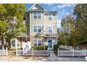 Inviting two-story townhome boasts a welcoming entrance and charming picket fence at 11700 Coppergate Dr # 100, Raleigh, NC 27614