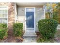 Close-up of a blue front door framed by lush greenery and stone accents at 11700 Coppergate Dr # 100, Raleigh, NC 27614