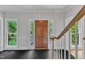 Inviting entryway with a dark tile floor, wooden front door, and views of the landscaped front yard at 11944 Appaloosa E, Raleigh, NC 27613
