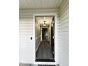 View of the foyer showing the front door opening to the updated floors and modern light fixture at 15 Colonial Hills Dr, Lillington, NC 27546