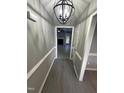 View down the hallway featuring updated floors, fresh paint, and decorative lighting at 15 Colonial Hills Dr, Lillington, NC 27546