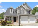 Charming two-story home featuring a two-car garage, complemented by a well-manicured front lawn and lush landscaping at 15 Epping Ct, Durham, NC 27703