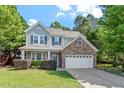 Charming two-story home with a stone accent, well-manicured lawn, and attached two-car garage at 1608 Hayesville Dr, Fuquay Varina, NC 27526