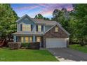 Charming two-story home with a stone accent, well-manicured lawn, and attached two-car garage at 1608 Hayesville Dr, Fuquay Varina, NC 27526