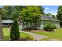 Home exterior with a brick walkway, manicured shrubs, and an evergreen tree showing the house from the side at 209 E Winston St, Youngsville, NC 27596