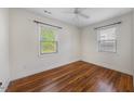 Bright bedroom with hardwood floors, neutral walls, a ceiling fan and two windows with blinds at 212 Northwood Cir, Durham, NC 27701
