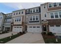 Townhome exterior with a two-car garage, complementary siding colors, and manicured landscaping at 2323 Hunter Woods Dr # 566, Apex, NC 27502