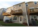 Townhome exterior showing an upper wood deck, neutral siding, and a ground-level patio space at 2323 Hunter Woods Dr # 566, Apex, NC 27502