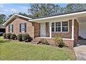 Charming brick home with a manicured lawn, complemented by dark shutters and a welcoming front porch at 2624 Gary Rd, Rocky Mount, NC 27803