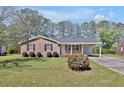 Traditional home boasts well-kept lawn, mature trees, and a brick facade with dark shutters at 2624 Gary Rd, Rocky Mount, NC 27803