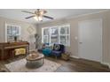 Living room bathed in natural light features wood-look floors, a cozy sofa, and a charming piano at 2624 Gary Rd, Rocky Mount, NC 27803