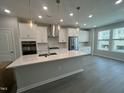 Modern kitchen featuring white cabinets, stainless steel appliances, and a large center island at 2723 Hunter Woods Dr # 566, Apex, NC 27502