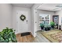 Bright foyer with a white front door adorned by a wreath, hardwood floors, and a view into the living space at 2923 Cullens Dr, Graham, NC 27253