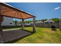 Well-maintained backyard features a patio with a gazebo, lush lawn, and privacy fence at 33 White Ash Dr, Clayton, NC 27527