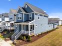 Attractive two-story residence with blue siding, a covered front porch, and a neatly landscaped yard, creating great curb appeal at 353 Rivella Dr, Wake Forest, NC 27587