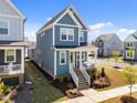 Stylish two-story home boasting blue siding, a cozy front porch, and lush landscaping, perfect for suburban living at 353 Rivella Dr, Wake Forest, NC 27587
