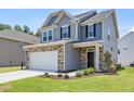 Two-story home featuring stone accents, attached garage, and a well-manicured lawn at 364 Peach Grove Way, Lillington, NC 27546