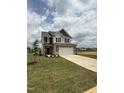 Charming two-story home with stone facade, two-car garage, and inviting curb appeal at 364 Peach Grove Way, Lillington, NC 27546