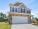Two-story home boasts a large driveway, attached garage, and a well-maintained lawn under a clear blue sky at 364 Peach Grove Way, Lillington, NC 27546