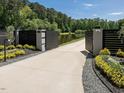 Elegant gated entrance with landscaped flower beds and a private driveway leading to the stunning home at 4001 Campbell Rd, Raleigh, NC 27606