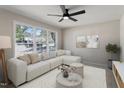 Bright living room features a large window, sectional sofa, ceiling fan, and neutral decor at 4204 Green Rd, Raleigh, NC 27604