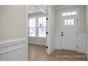 Bright entryway featuring clean white trim, with the front door and a living room with windows at 436 Golden Dragonfly St, Wake Forest, NC 27587