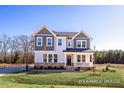 Beautiful two-story home with a covered front porch, stone accents, gray siding, and a well-manicured lawn at 436 Golden Dragonfly St, Wake Forest, NC 27587