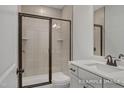 Modern bathroom with a glass-enclosed shower, tile accents, and a vanity with updated fixtures at 440 Golden Dragonfly St, Wake Forest, NC 27587