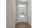 Bright entryway with hardwood floors and a door featuring glass panes that look out onto a lush, green landscape at 440 Golden Dragonfly St, Wake Forest, NC 27587
