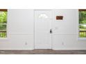 Bright entryway featuring a white door with a decorative window, light gray walls, and two windows at 5346 Deep River Rd, Sanford, NC 27330