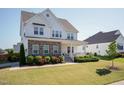 Inviting two-story home with stone accents, a charming front porch, and lush landscaping on a sunny day at 536 Adkins Ridge Rd, Rolesville, NC 27571