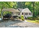 Charming one-story home with white siding, landscaped yard, and a covered parking area for vehicles and boats at 5414 Stanley Rd, Durham, NC 27704