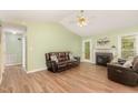 Cozy living room with a fireplace, wood flooring, and an open layout to other rooms at 5600 Sherrif W Pl, Raleigh, NC 27610