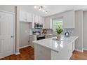 Bright kitchen features white cabinets, stainless steel appliances, and quartz countertops at 5612 Sandy Trail Dr, Knightdale, NC 27545