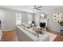 Bright living room featuring a ceiling fan, fireplace, and large windows for natural light at 5612 Sandy Trail Dr, Knightdale, NC 27545