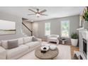 Bright living room featuring a comfortable white couch and natural light from large windows at 5612 Sandy Trail Dr, Knightdale, NC 27545