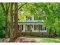 Inviting two-story home with a covered front porch, complete with classic black shutters and beautiful landscaping at 5701 Hadrian Dr Dr, Durham, NC 27703