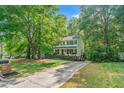 Charming two-story home featuring a welcoming front porch and a well-manicured front yard surrounded by mature trees at 5701 Hadrian Dr Dr, Durham, NC 27703