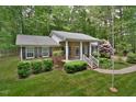 Traditional brick home with manicured landscaping, inviting front porch and lush green surroundings at 5825 Scalybark Rd, Durham, NC 27712