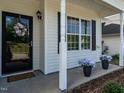Close-up of a welcoming front porch with potted plants and a decorative wreath at 637 Prickly Pear Dr, Fuquay Varina, NC 27526