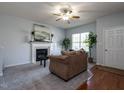 Cozy living room featuring a fireplace, plush sofa, and large window for natural light at 637 Prickly Pear Dr, Fuquay Varina, NC 27526