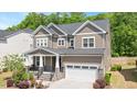 Charming two-story home with a landscaped front yard and inviting front porch, plus a two car garage at 745 Orange Oak Ln, Apex, NC 27523