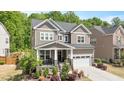 Charming two-story home with a landscaped front yard and inviting front porch, plus a two car garage at 745 Orange Oak Ln, Apex, NC 27523