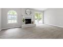 Bright living room featuring a cozy fireplace, arched window, and sliding glass door at 7824 Knightdale Blvd, Knightdale, NC 27545