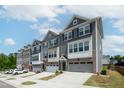Modern townhomes feature multi-toned exteriors and attached garages with driveways at 805 Grafton Peak Lane Ln, Apex, NC 27523