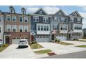 Modern townhomes feature multi-toned exteriors and attached garages with driveways at 805 Grafton Peak Lane Ln, Apex, NC 27523